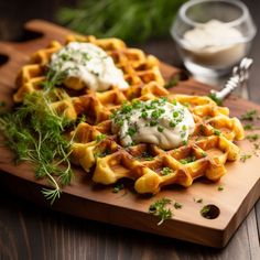 a wooden cutting board topped with waffles covered in sauce and garnished with parsley