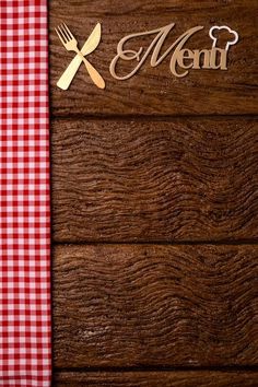 a wooden table topped with a red and white checkered table cloth next to a knife and fork