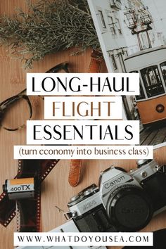 a table with an old camera, book and other items on it that says long - haul flight essentials turn economy into business class