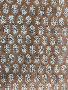 a brown and white patterned fabric with flowers on the side, in very close up