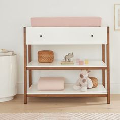 a baby's nursery room with pink and white decor