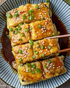 tofu with sesame seeds and green onions in a bowl