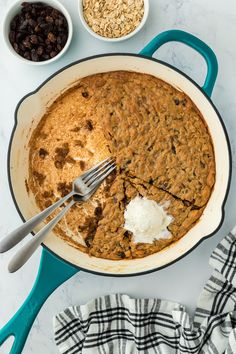 a pan filled with oatmeal and raisins next to other ingredients