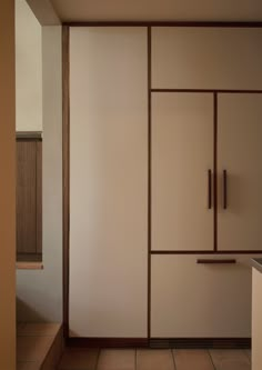 an empty room with white walls and brown trimmings on the sliding doors, in front of a sink