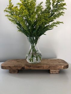 a vase filled with flowers sitting on top of a wooden stand