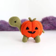 a stuffed turtle with a pumpkin on its back