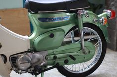 a green and white motorcycle parked in a garage