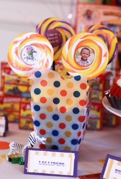 a table topped with lots of lollipops and cupcakes on top of it