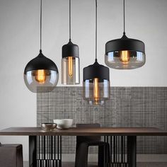 three lights hanging from the ceiling above a table