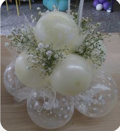 an arrangement of balloons and flowers on a table