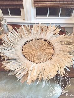 a large sunflower sitting on top of a rug next to a window sill