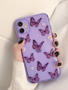 a woman's hand holding a purple phone case with butterflies on it