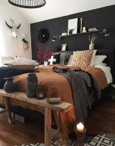 a bed room with a neatly made bed next to a wooden table and two candles