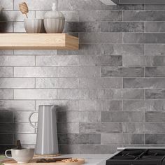 a stove top oven sitting inside of a kitchen next to a shelf with cups on it