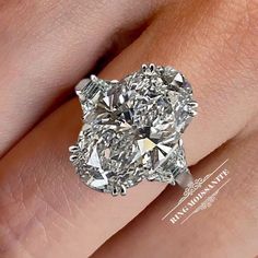 a close up of a person's hand with a diamond ring on it