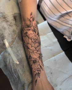 a woman's arm with a flower tattoo on the left side of her leg