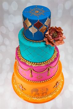 a multi - tiered cake with an elephant on top is decorated in bright colors