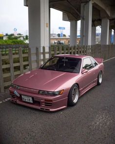 a pink car parked on the side of a road