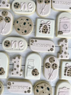 cookies decorated with different designs and words on white wood planks that spell out the word me