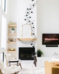 a living room filled with furniture and a flat screen tv mounted on the wall above a fire place