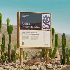 a sign in the middle of some rocks and cacti