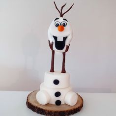 a cake made to look like a snowman on top of a tree stump with the youtube logo above it