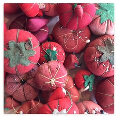 red apples and oranges wrapped in twine with green leaves on the top, sitting next to each other