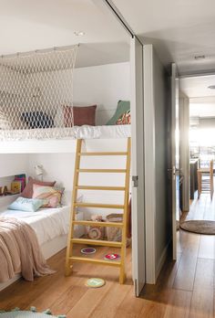 a room with bunk beds and a ladder in the floor next to a door that leads to another room