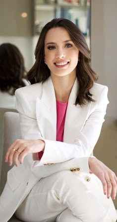 a woman in a white suit sitting on a chair