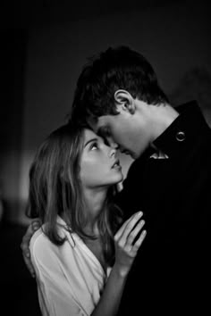 black and white photograph of a man kissing a woman