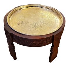 an ornately carved wooden table with metal tray