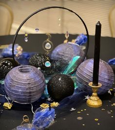 a table topped with lots of different colored glass balls and candle holders on top of it