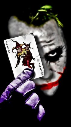 the joker holding up a playing card in his hand