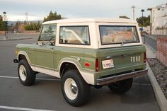 a green and white pick up truck parked in a parking lot