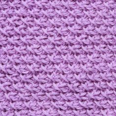 close up view of the crochet pattern on a purple knitted blanket or shawl