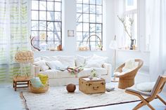 a living room filled with lots of furniture and decor on top of a white rug