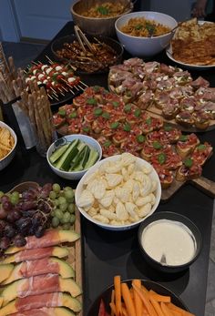 an assortment of food is displayed on a buffet table with dips and crackers