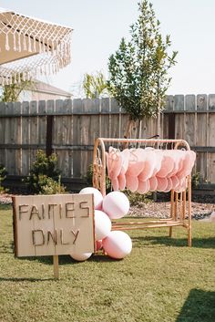 a sign that says families only on it in front of some pink and white balloons