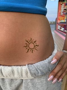 a woman with a sun tattoo on her stomach