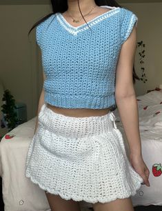 a woman wearing a blue top and white skirt