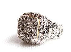 a large silver ring with lots of diamonds on the front and sides, set against a white background