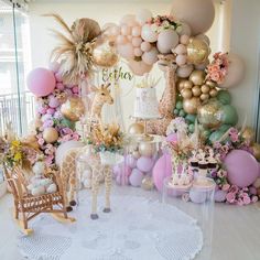 a room filled with lots of pink and gold balloons, giraffes, and other decorations