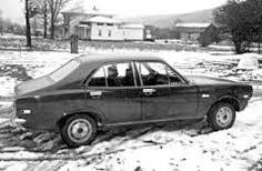 an old black and white photo of a car in the snow