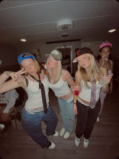 four girls in white shirts and ties posing for the camera with their hands on their hipss