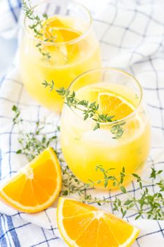 two glasses filled with lemonade and garnished with herbs