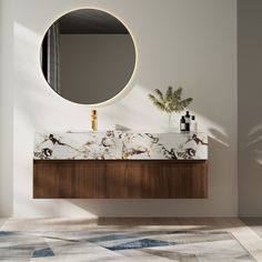 a bathroom with a marble counter top and round mirror above the sink, along with a plant