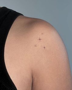 the back of a woman's shoulder with small stars on it