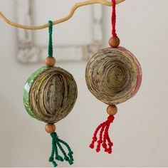 an ornament hanging from a tree branch with beads and tassels on it