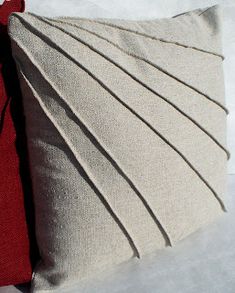 a red and white pillow sitting on top of snow covered ground