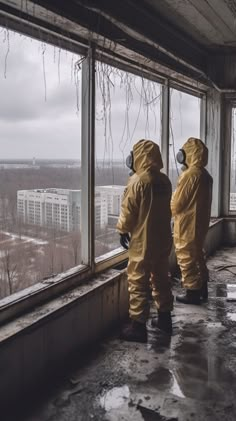 two people in yellow suits looking out the window at buildings outside them on a cloudy day